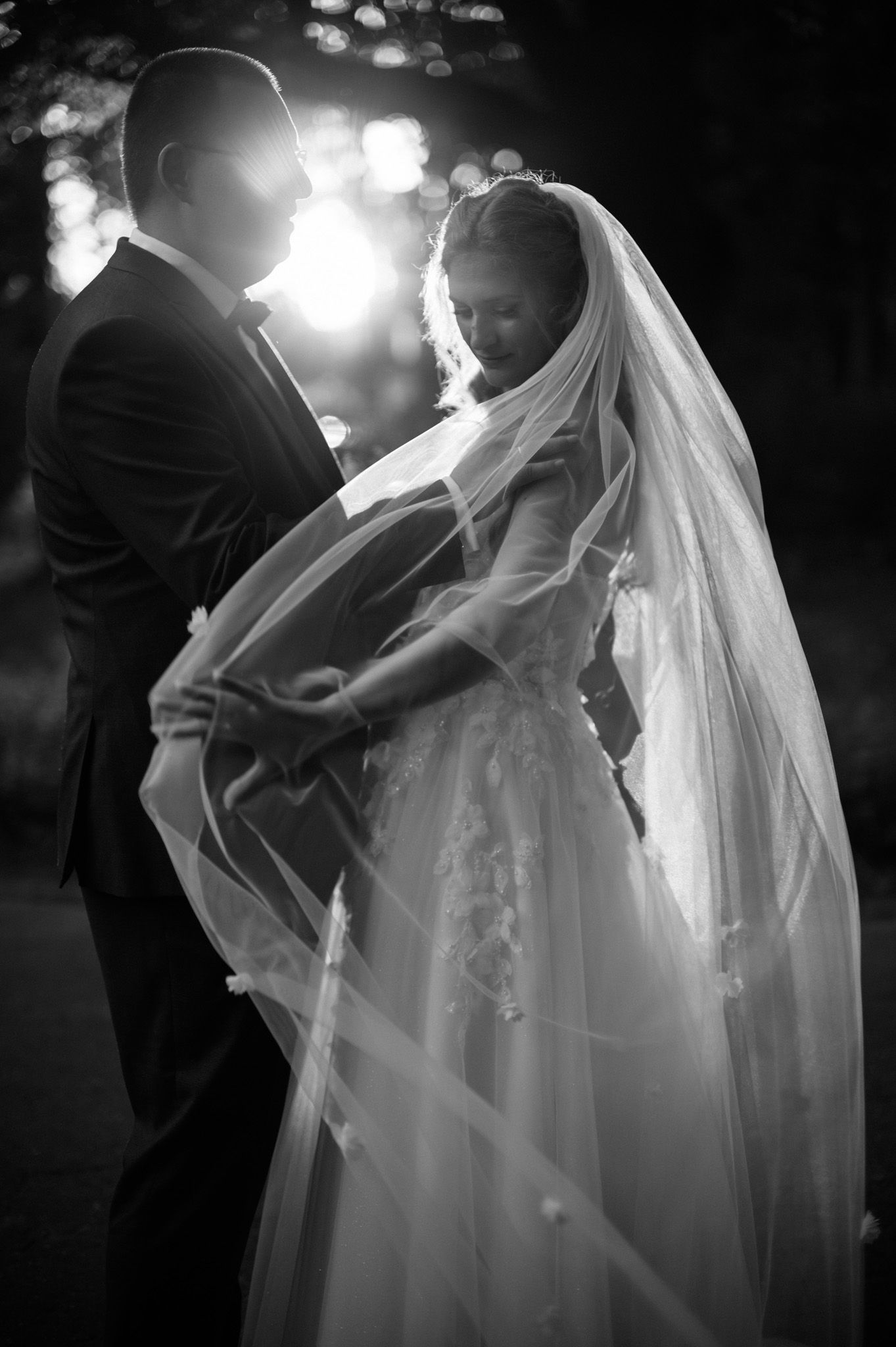 A romantic black and white wedding dance sequence showing a bride's flowing veil and silhouetted couple in motion.