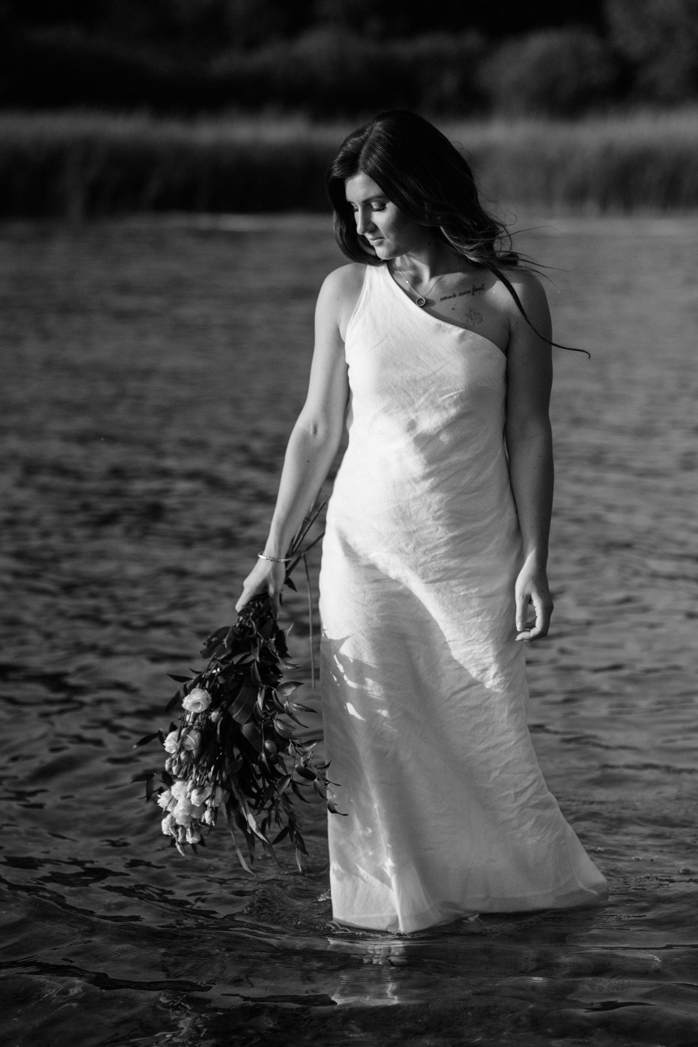 A sequence of artistic black and white photos showing a white dress flowing in water with a bouquet.