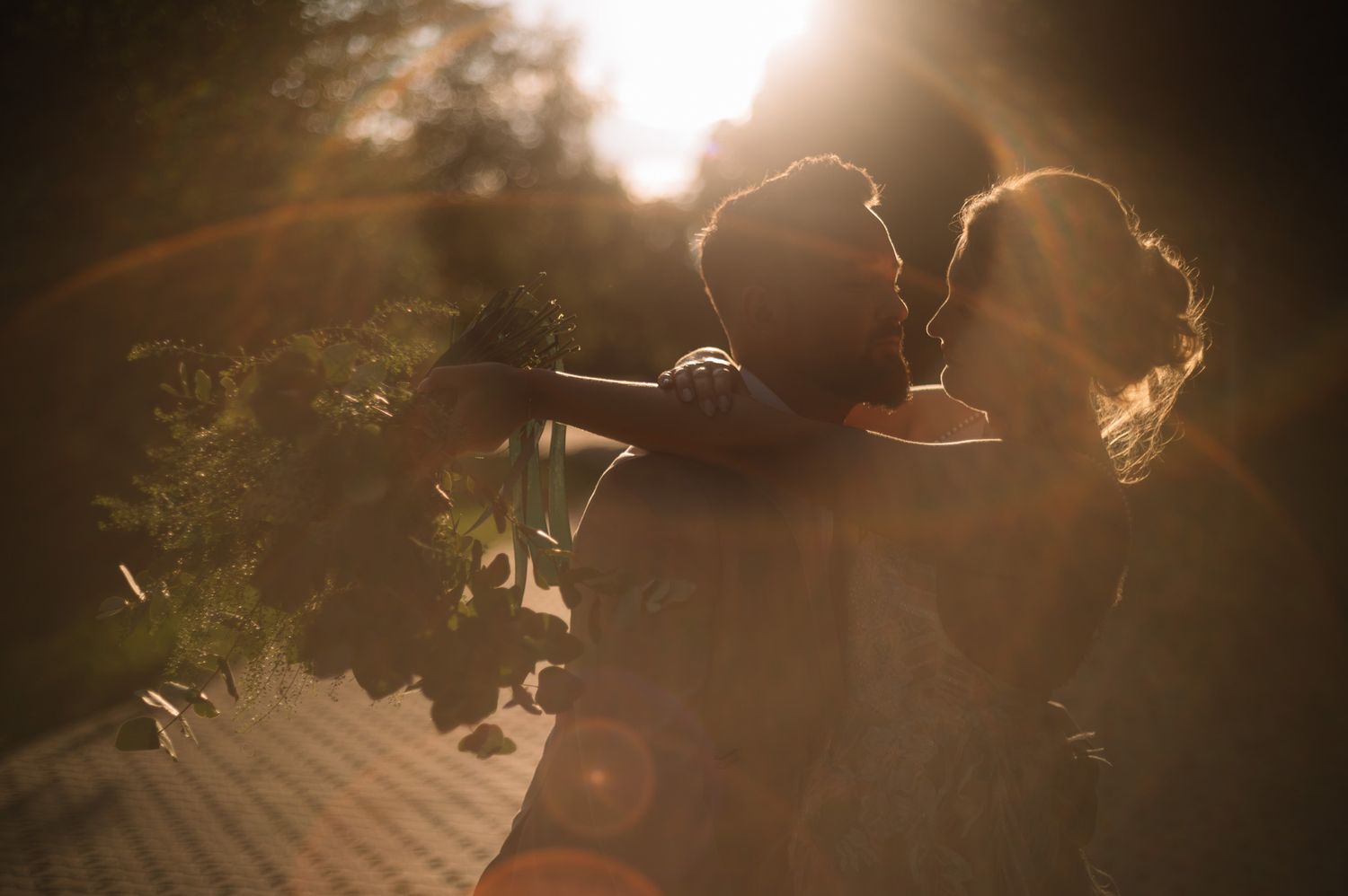 A silhouetted figure in a cowboy hat stands against a warm golden sunset creating a dramatic backlit scene.