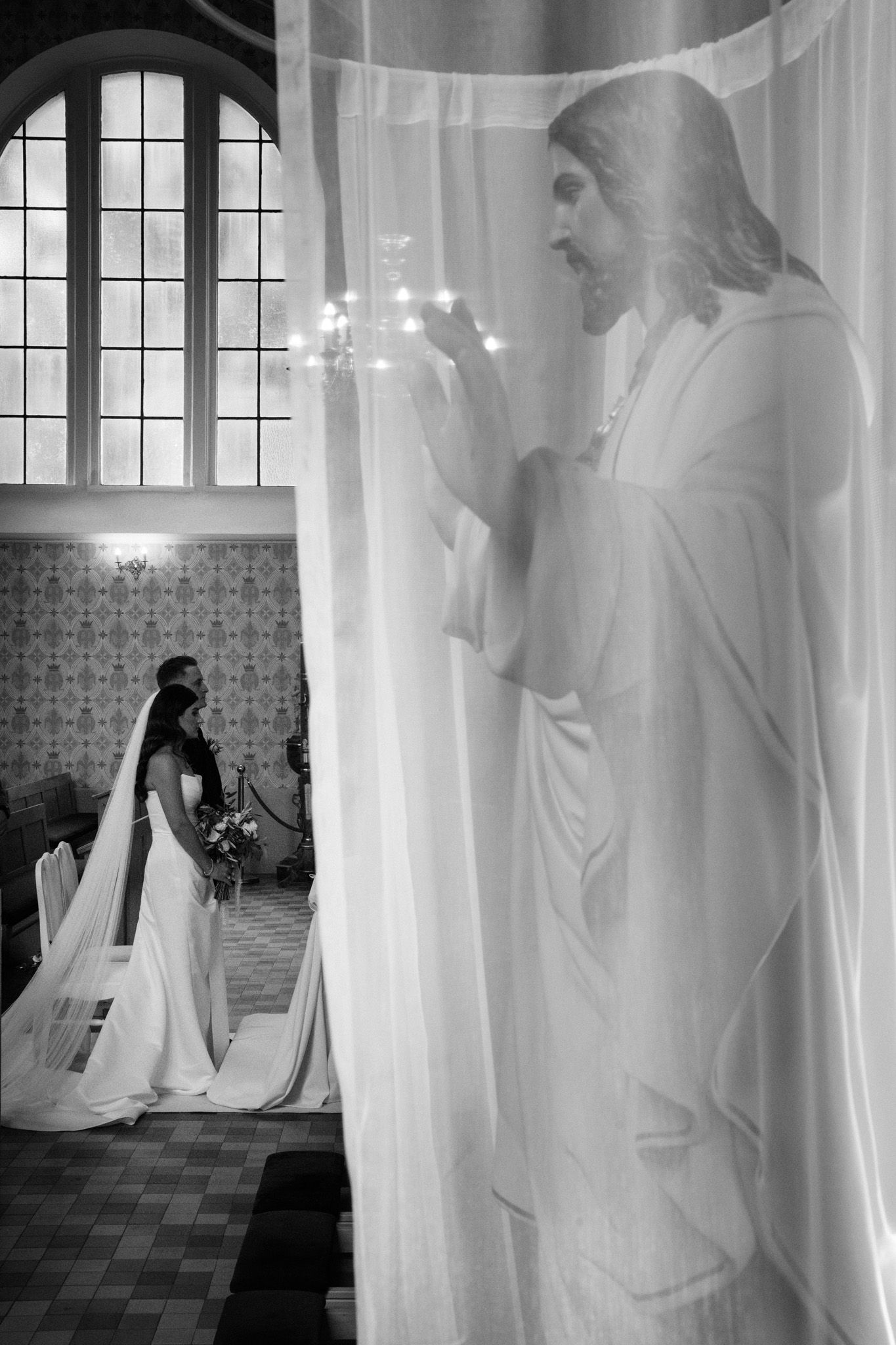 A series of black and white photographs showing ethereal figures in flowing white veils moving through a church interior.