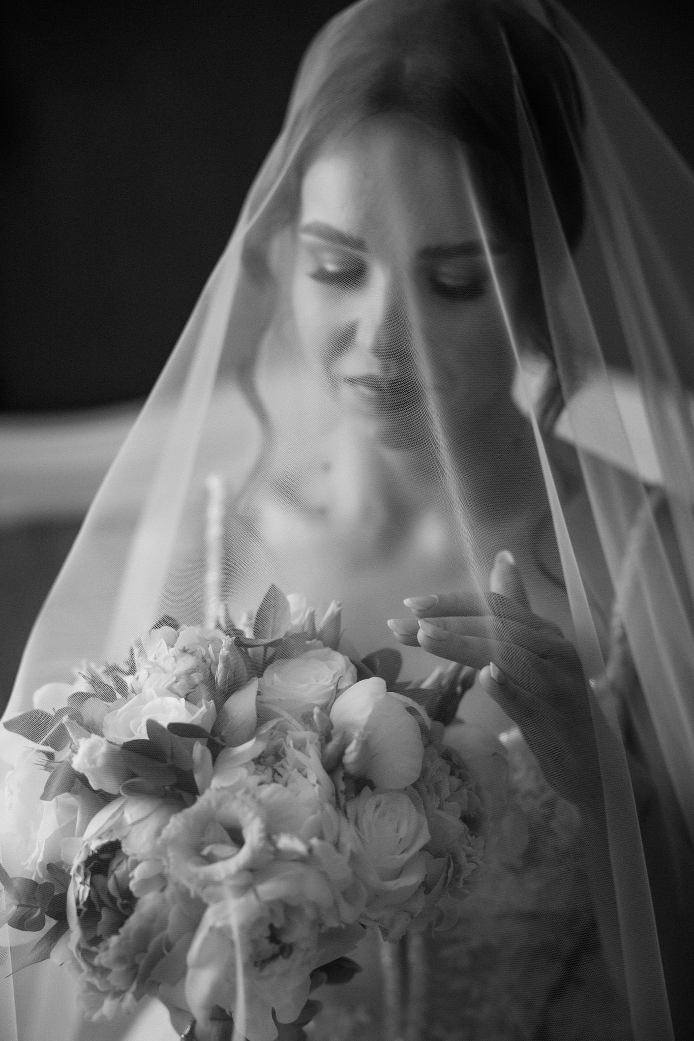 A black and white series of bridal portraits showing a veiled bride holding a delicate white floral bouquet.