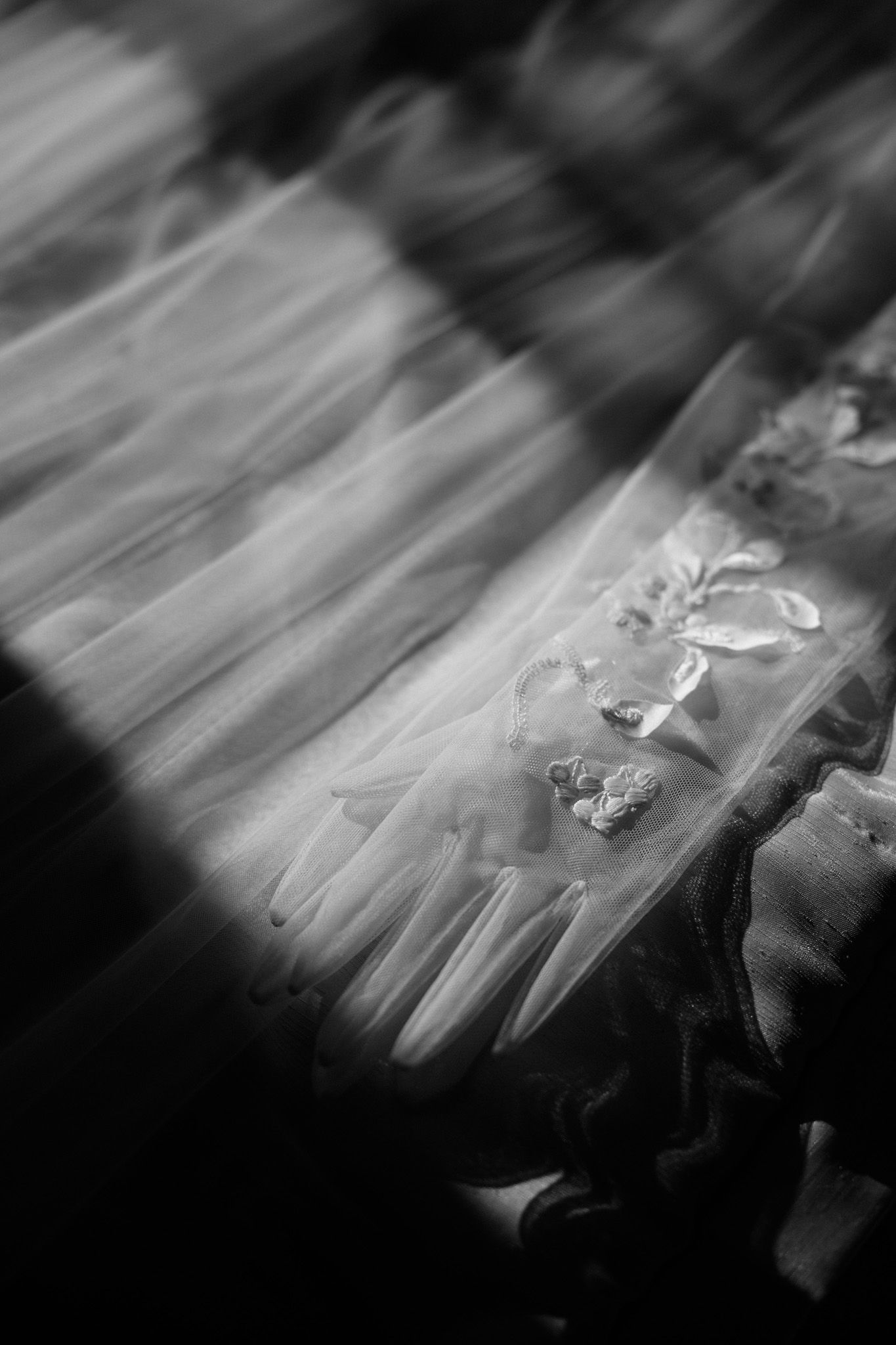 Blurred black and white motion photograph shows dancers in white dresses creating an ethereal effect.