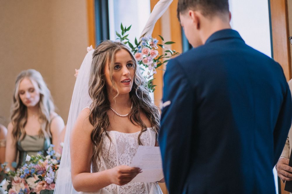 Couple exchanges vows during intimate indoor wedding ceremony.