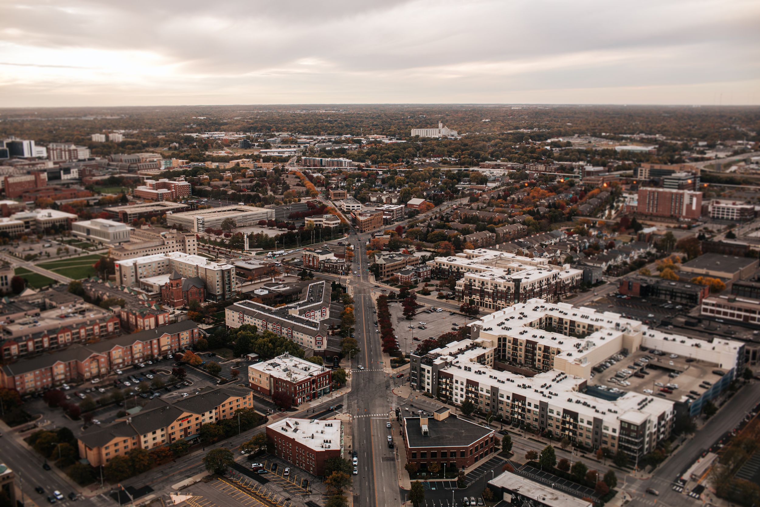 Aerial panoramic view of a city skyline with modern buildings and streets stretching into the distance.