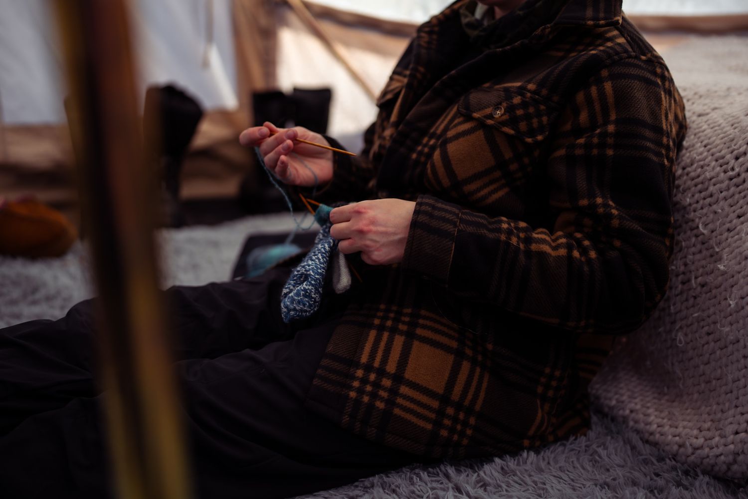 A series of seven connected images showing hands knitting with brown yarn on wooden needles.