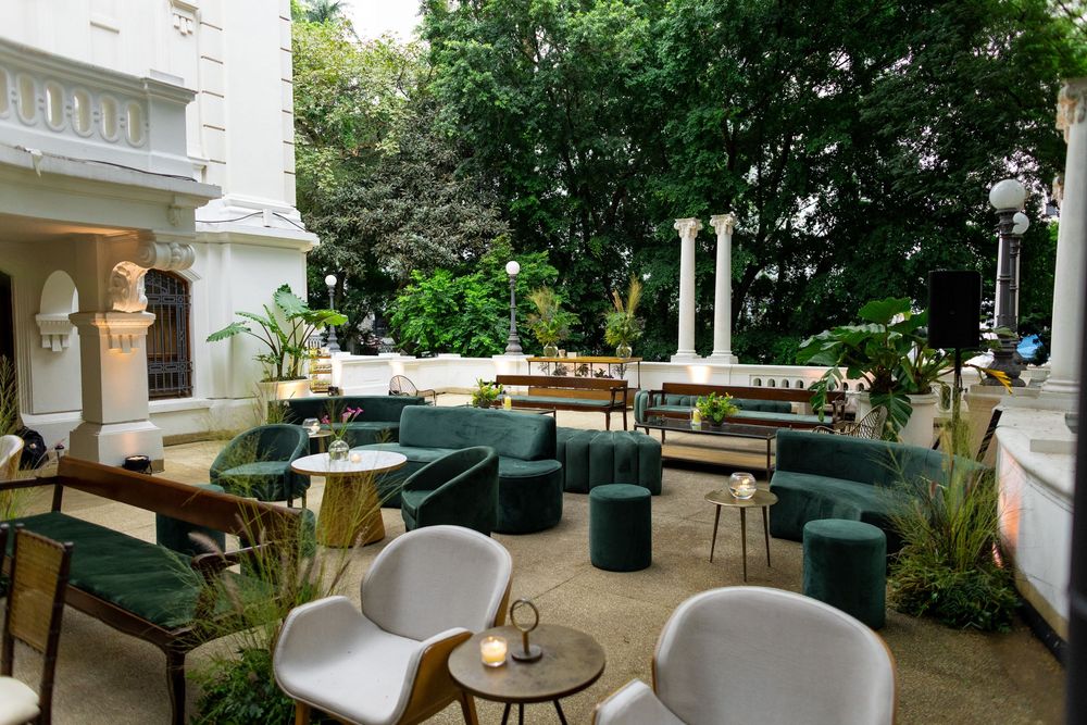 Modern terrace dining space with green and white furniture under a covered patio.