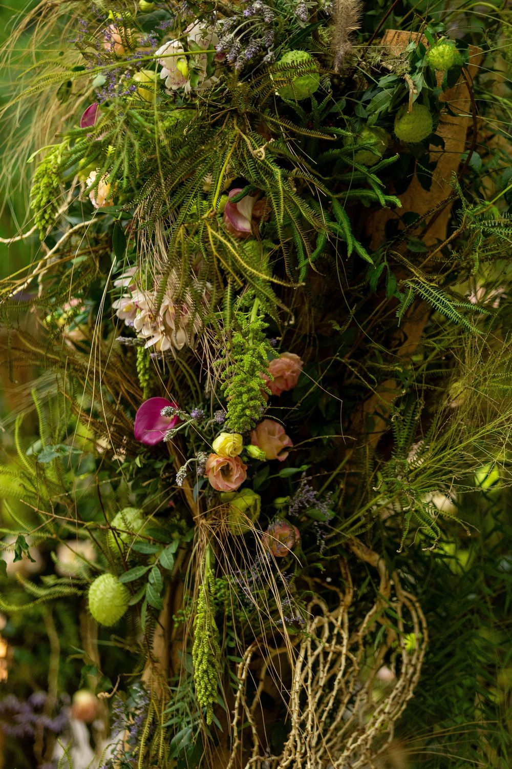 Lush hanging garden installation with mixed flowers, vines, and natural greenery.