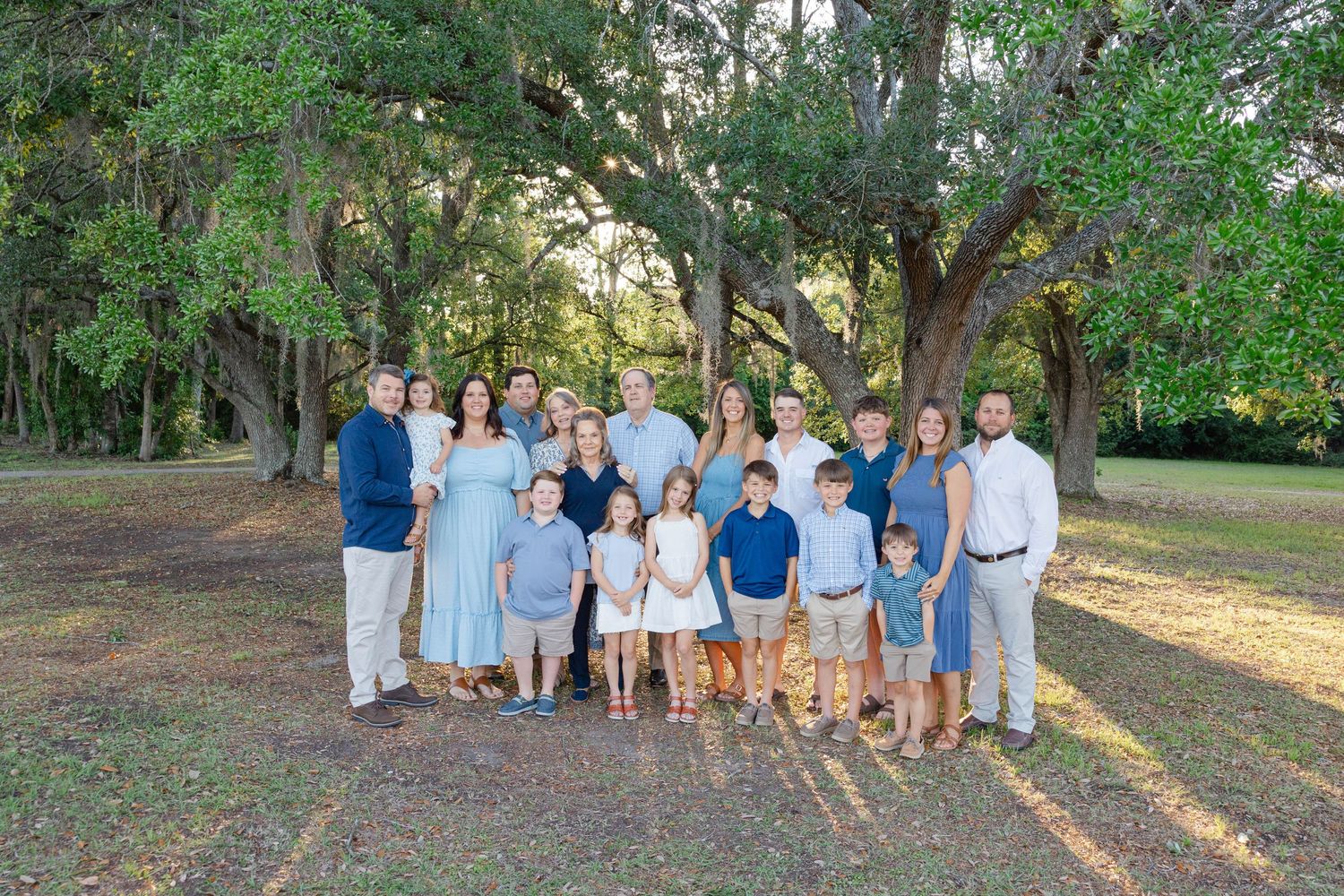 Large family standing together on the beach at sunset.
