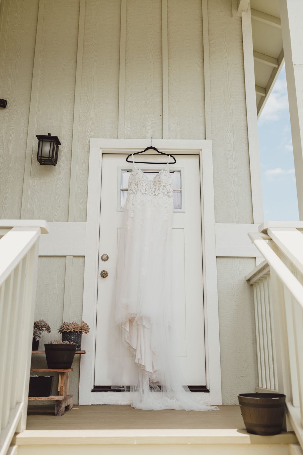 Three white paneled doors with rustic hardware and wooden trim on a cream colored exterior wall.