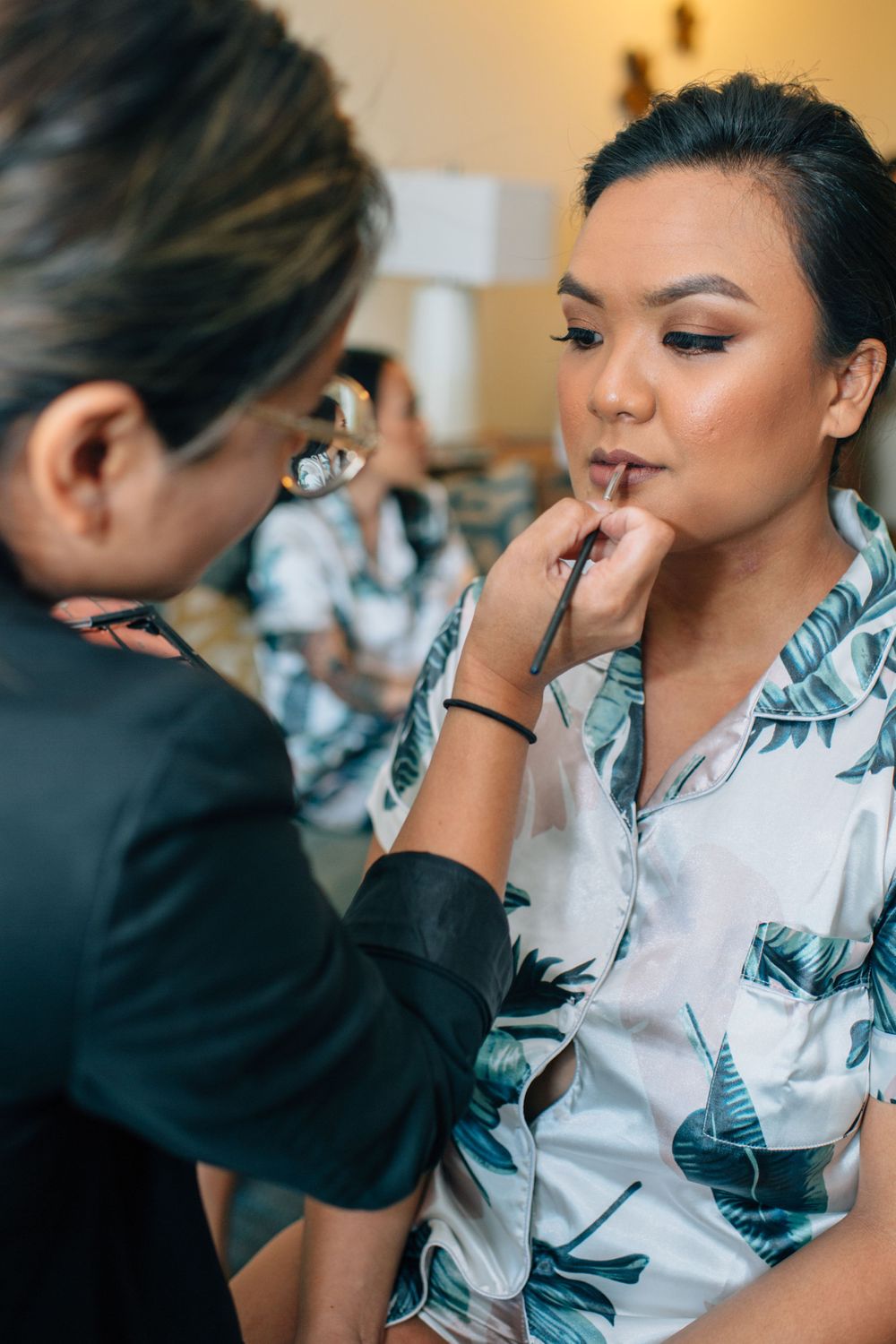 Professional makeup artist applying cosmetics during bridal preparation.
