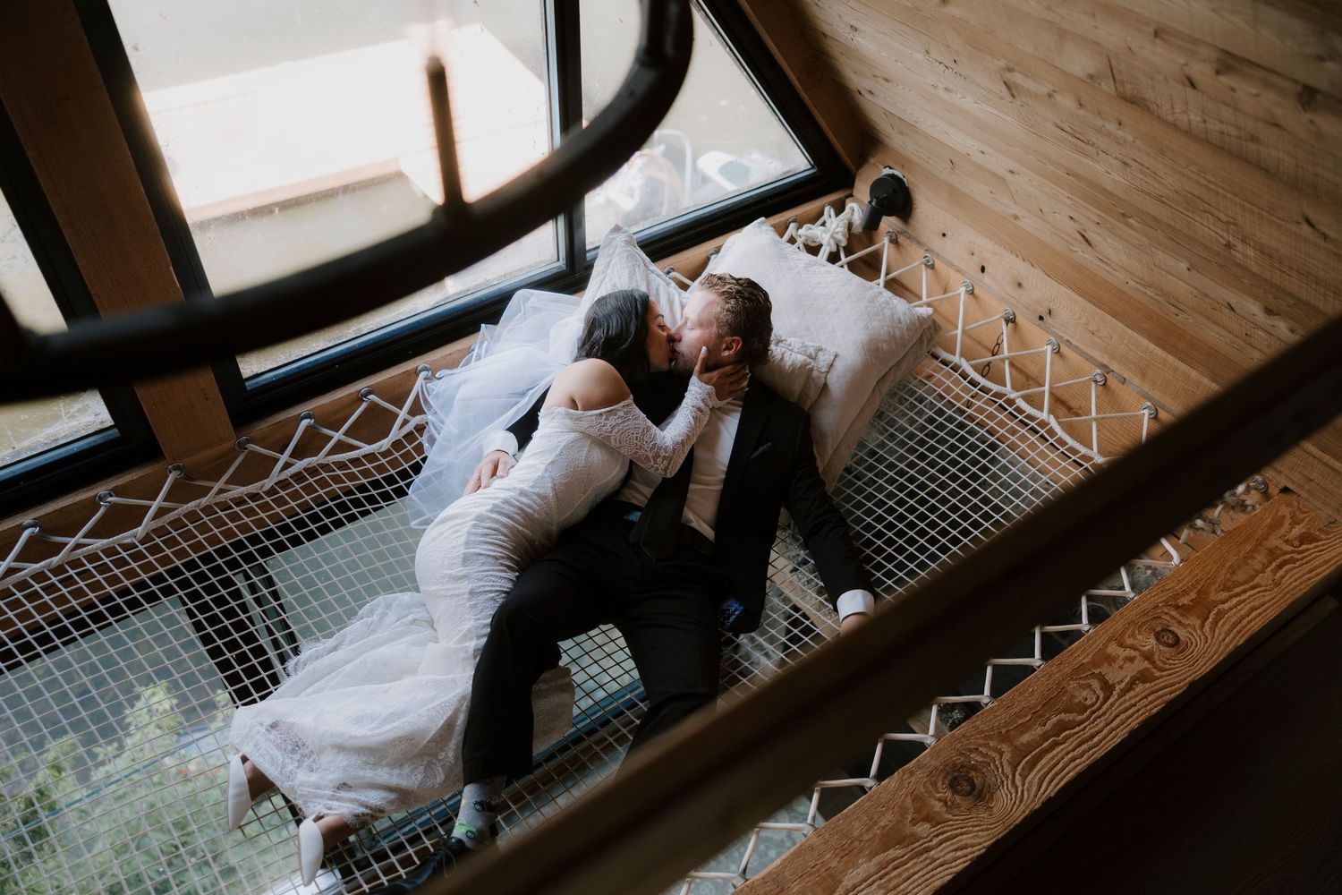 A romantic wedding couple embraces on a lush green golf course under a bright blue sky.