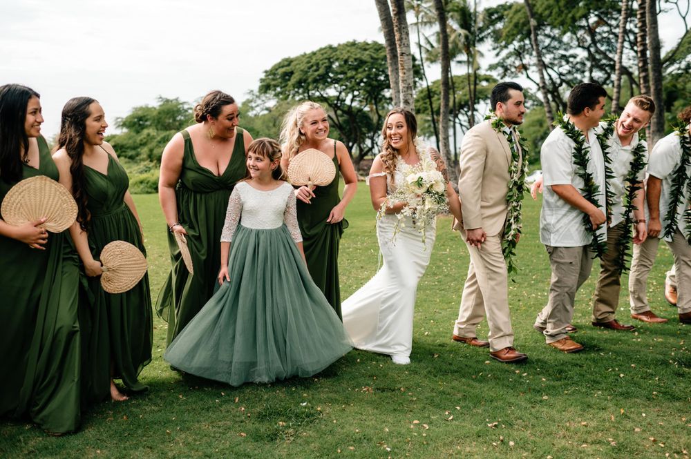 Wedding guests dancing and celebrating at an outdoor reception in a tropical garden setting.