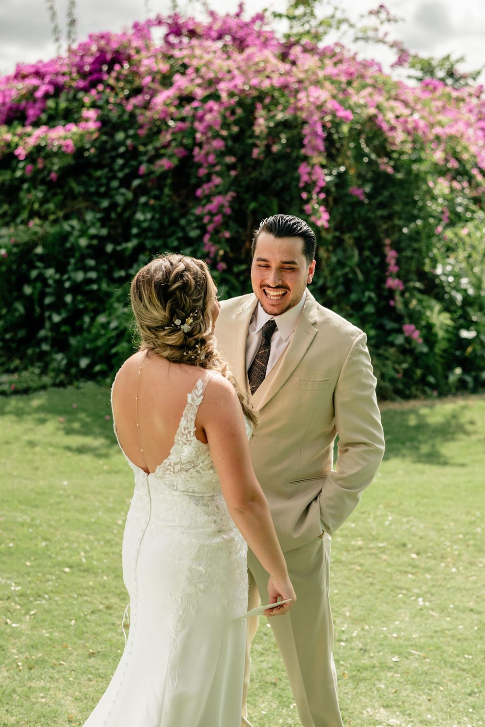 Couple sharing a joyful moment in front of vibrant pink bougainvillea flowers.