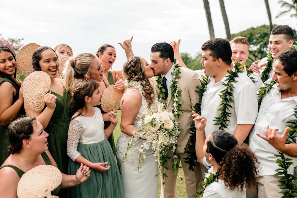 Wedding party celebrating outdoors with joyful expressions and festive atmosphere.