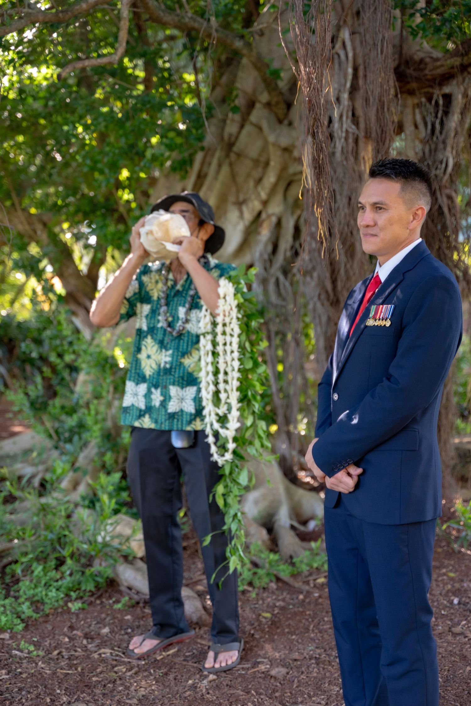 A sequence of romantic moments captured between a couple in formal attire beneath trees in a garden setting.