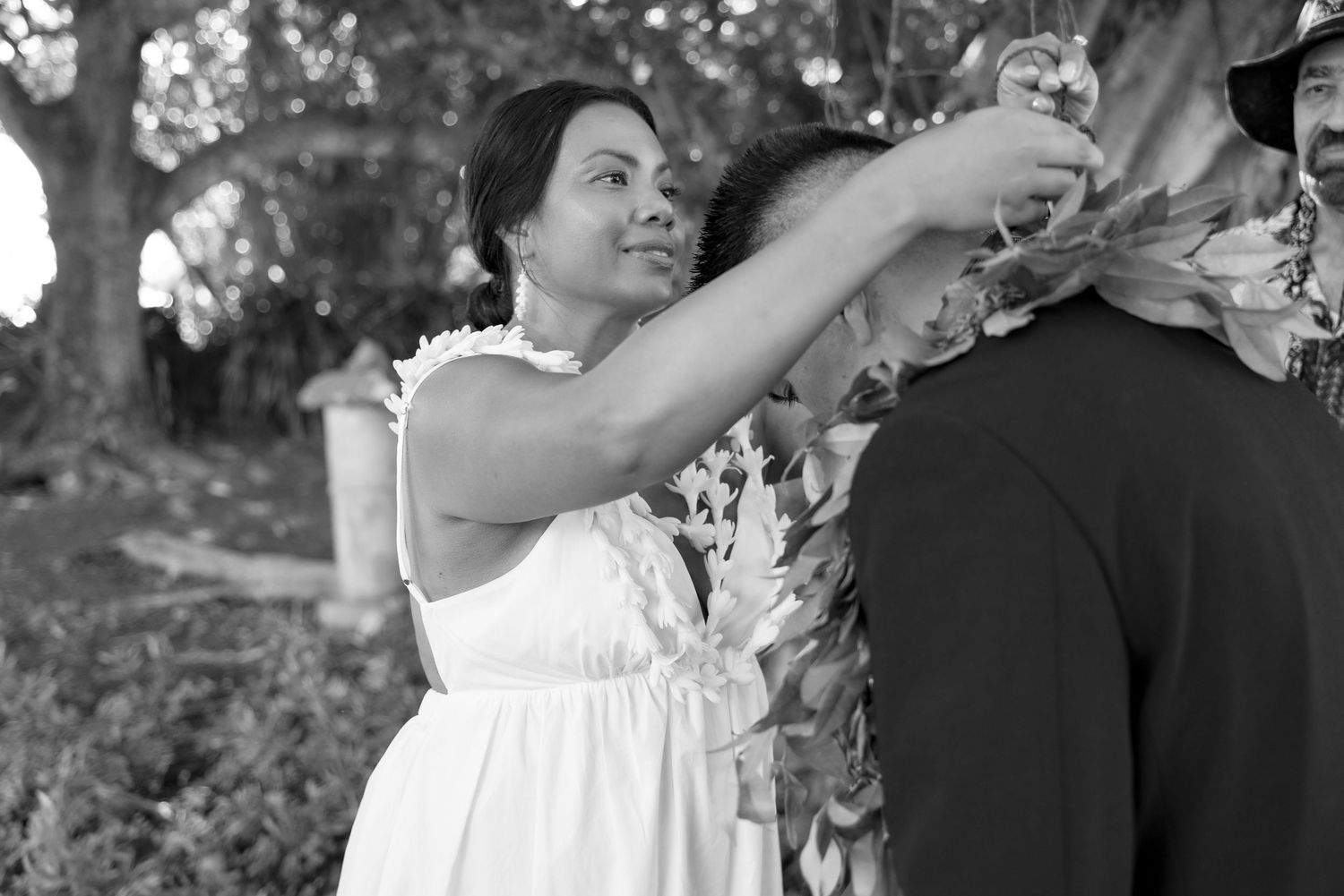A couple shares a romantic dance together at an outdoor wedding celebration in black and white.