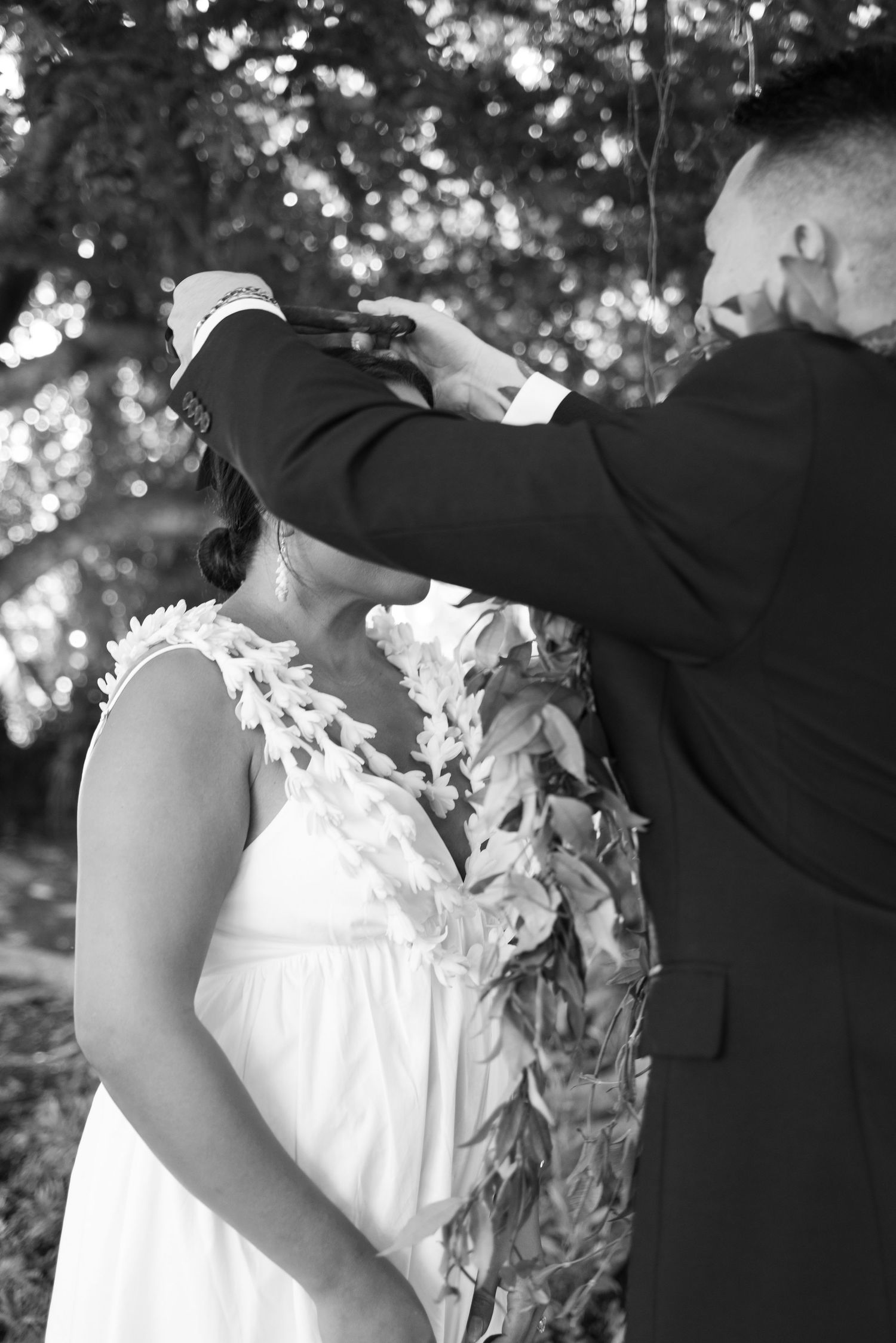 A series of black and white wedding photos showing romantic moments between a couple in formal attire.