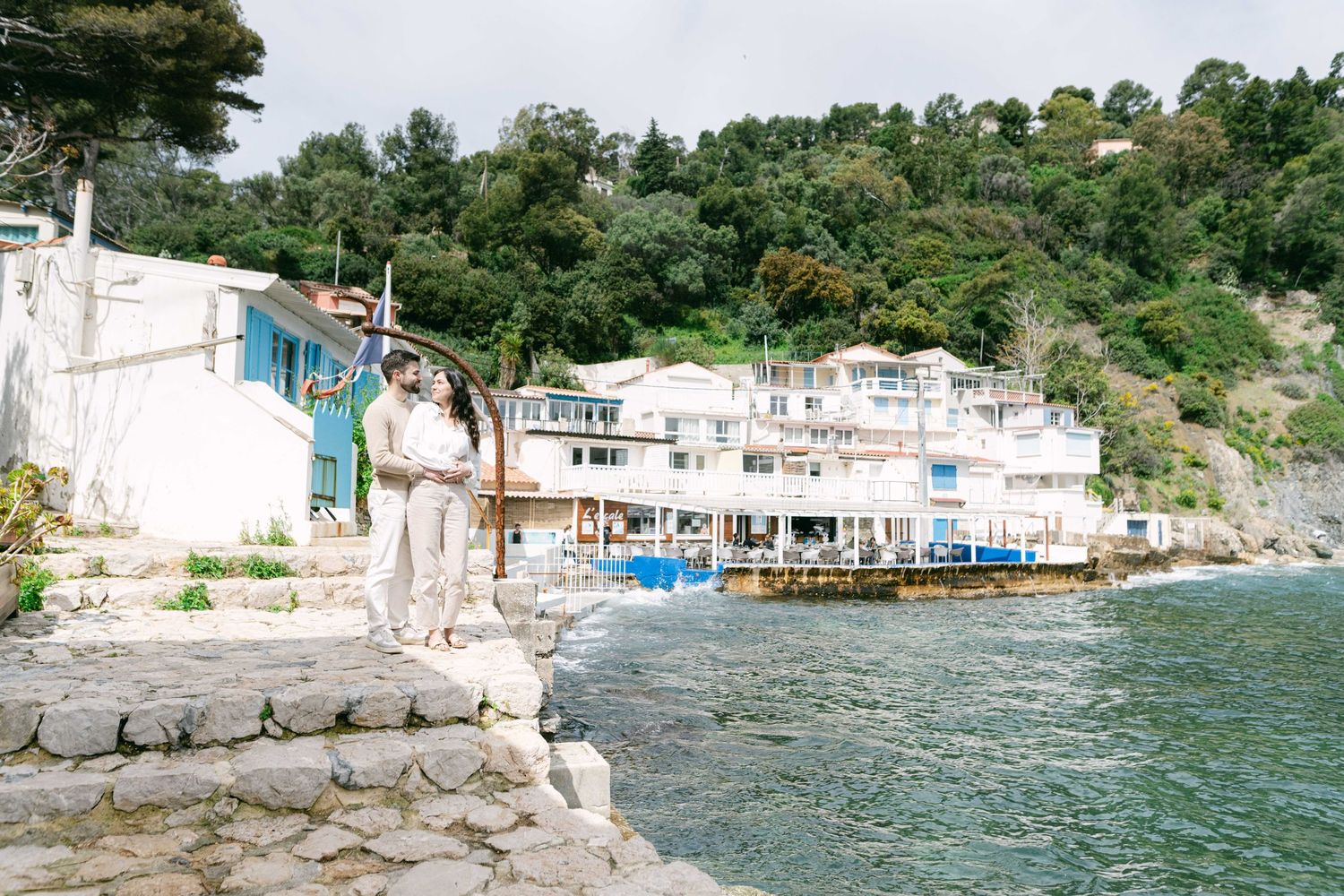 A picturesque Mediterranean seaside village with white buildings along a rocky coastline and blue waters.