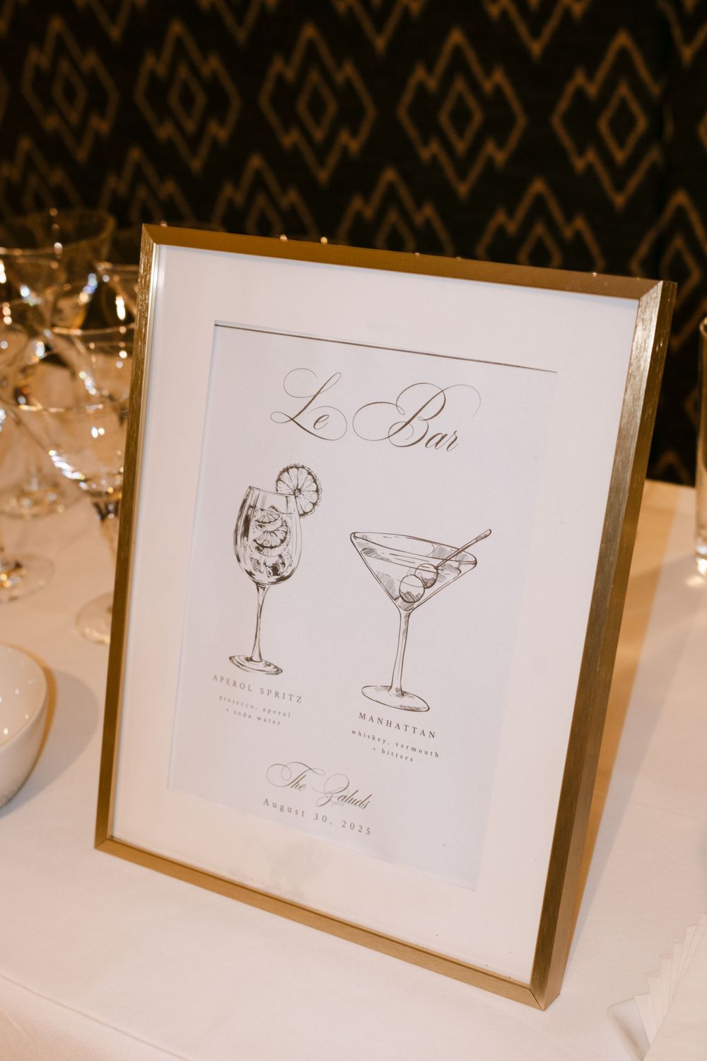 Elegant cocktail menu cards with martini glass illustrations displayed on white tablecloths.