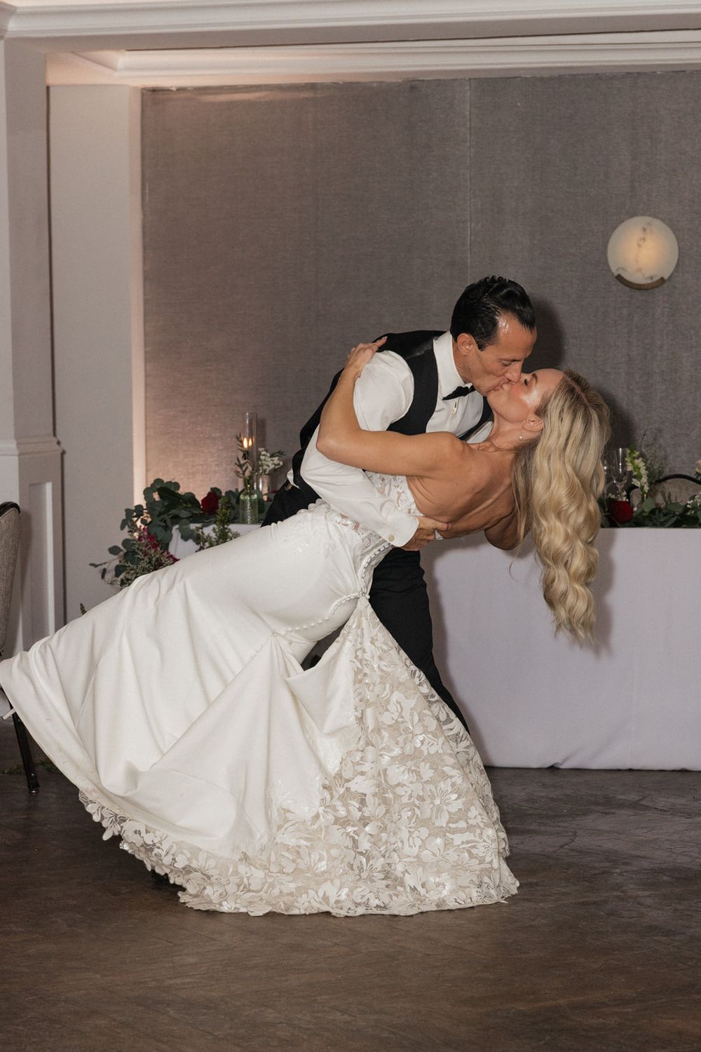 Romantic wedding dance dip sequence showing couple in white dress and black suit on dance floor.