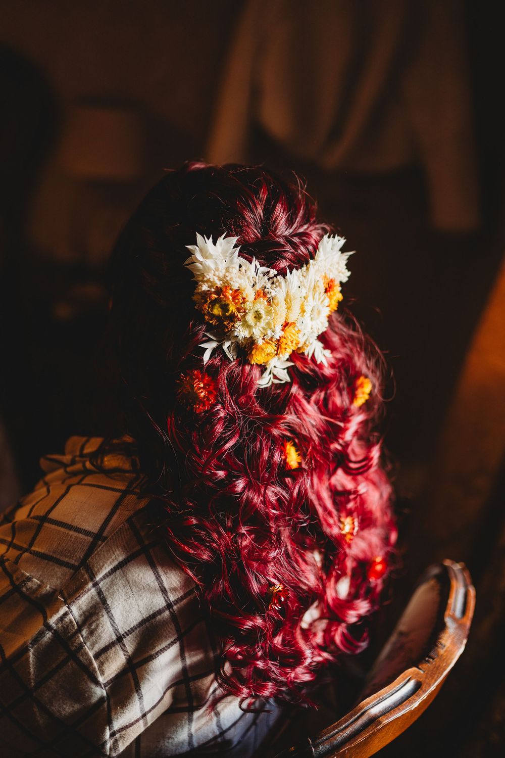 A dramatic floral bouquet with deep burgundy and white flowers photographed in moody lighting.