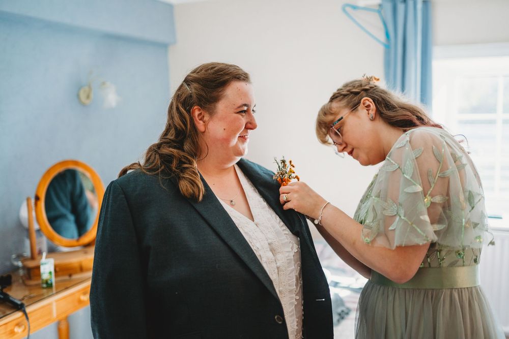 Candid moments captured during wedding preparations in a blue-walled room.