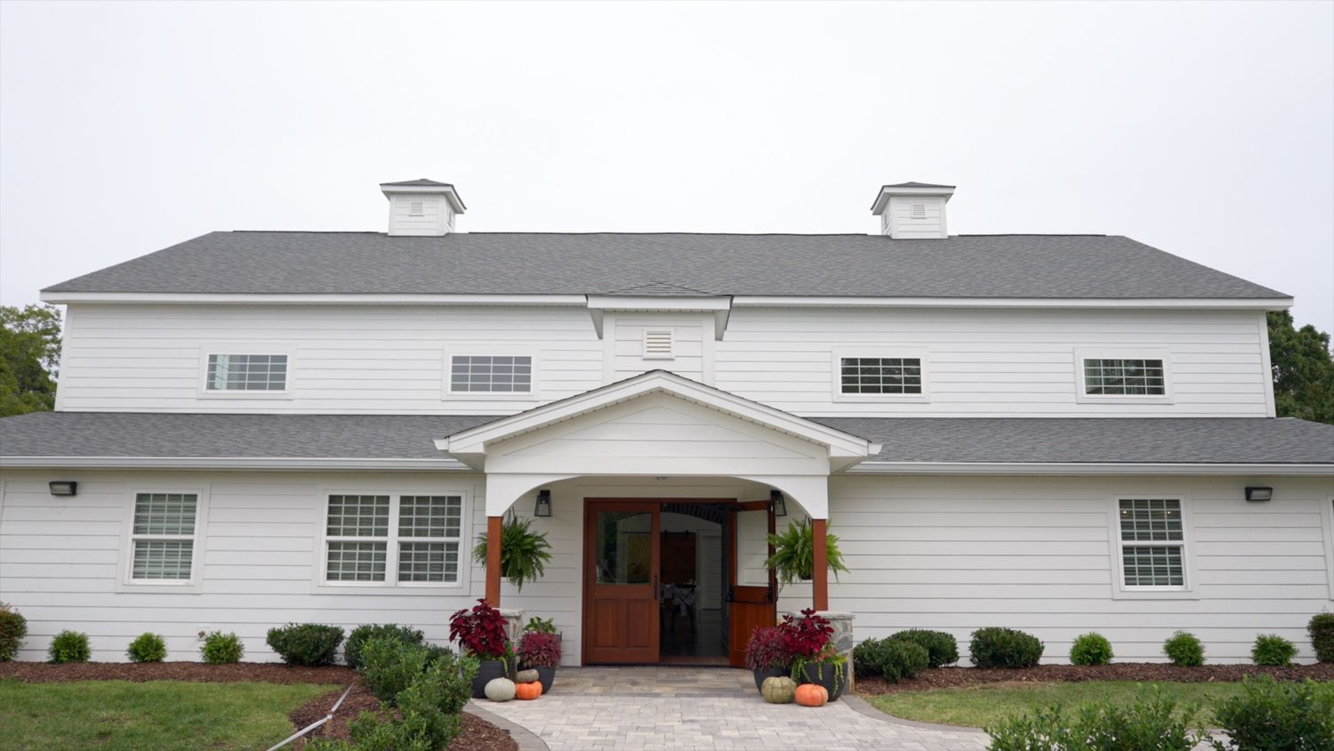 White ranch-style home exterior with gray roof and multiple windows showcases a modern residential design.