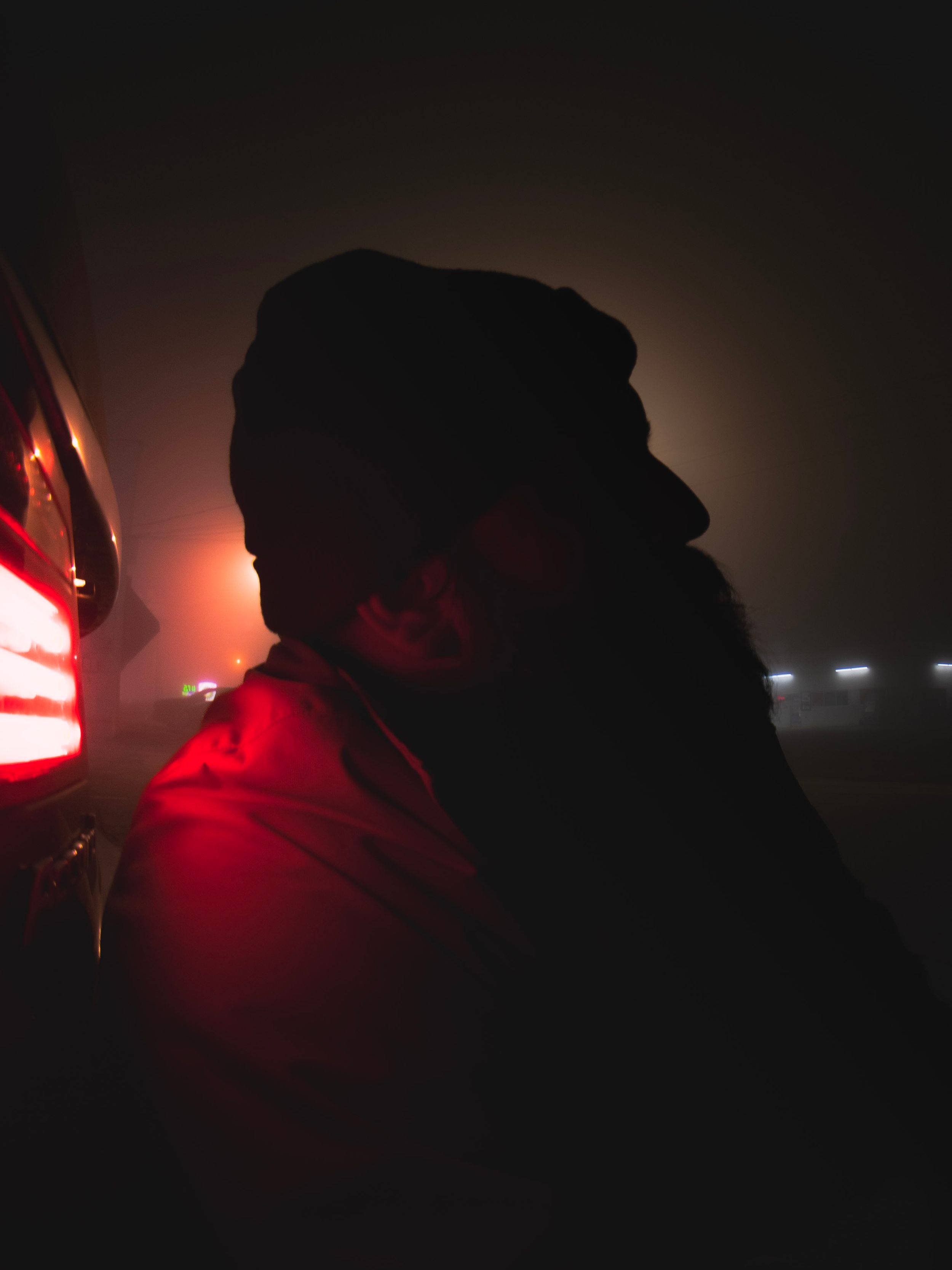 Dark silhouettes against moody red lighting create atmospheric shadows.