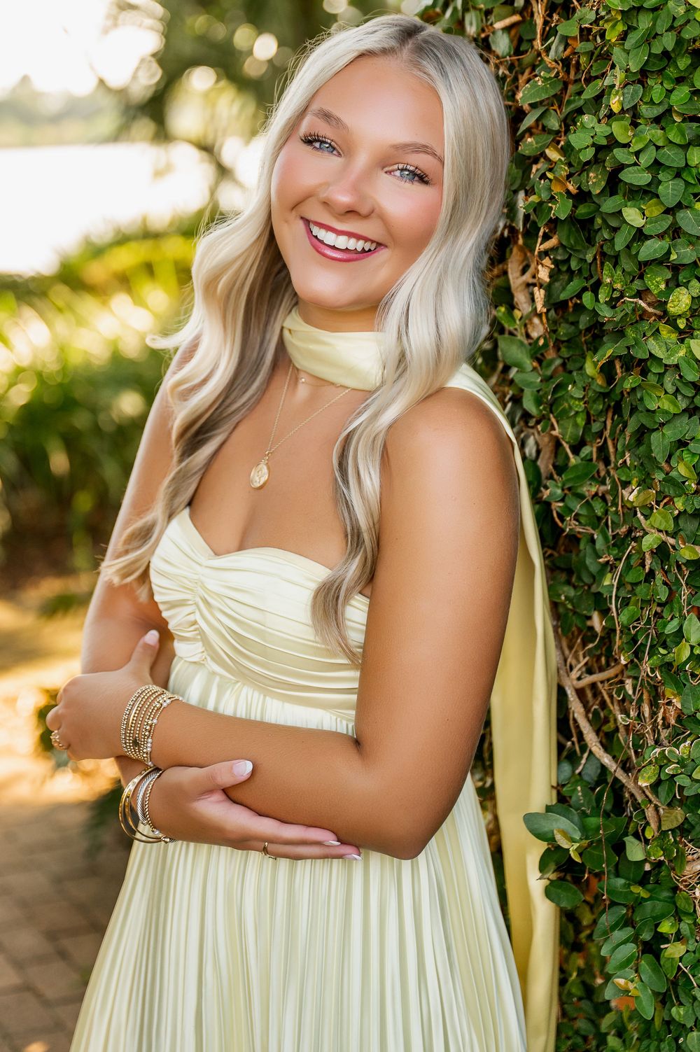 Soft yellow sundress photographed against ivy-covered garden wall in natural lighting.