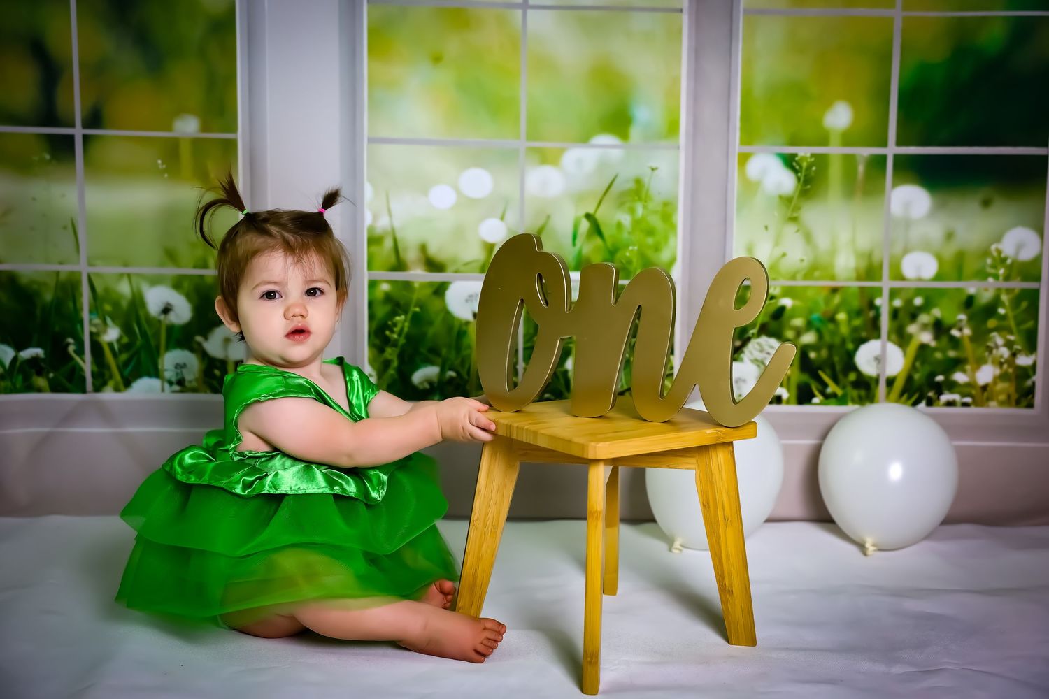 Indoor photoshoot setup with green dress and decorative white elements against a bright background.