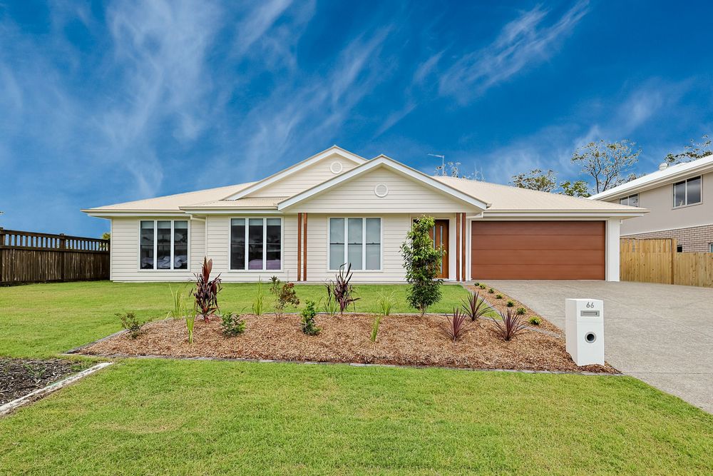 Bright daytime exterior of a modern family home with fresh landscaping, photographed for real estate listing marketing.