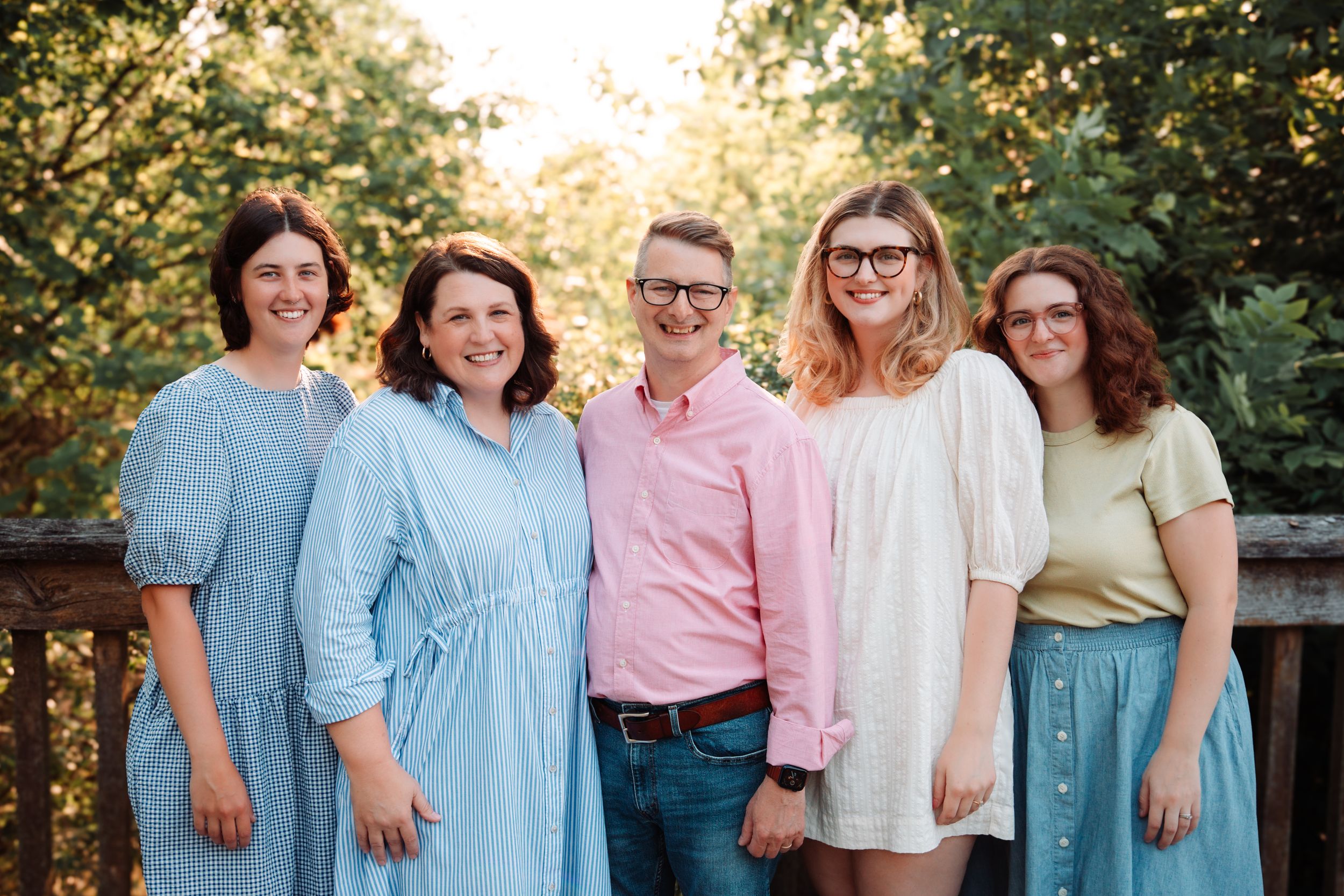 Extended family photos in coordinated pastel outfits during sunset photoshoot.