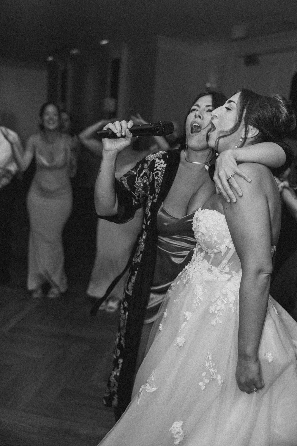 A group of wedding guests dancing and celebrating together on the dance floor at a reception party.