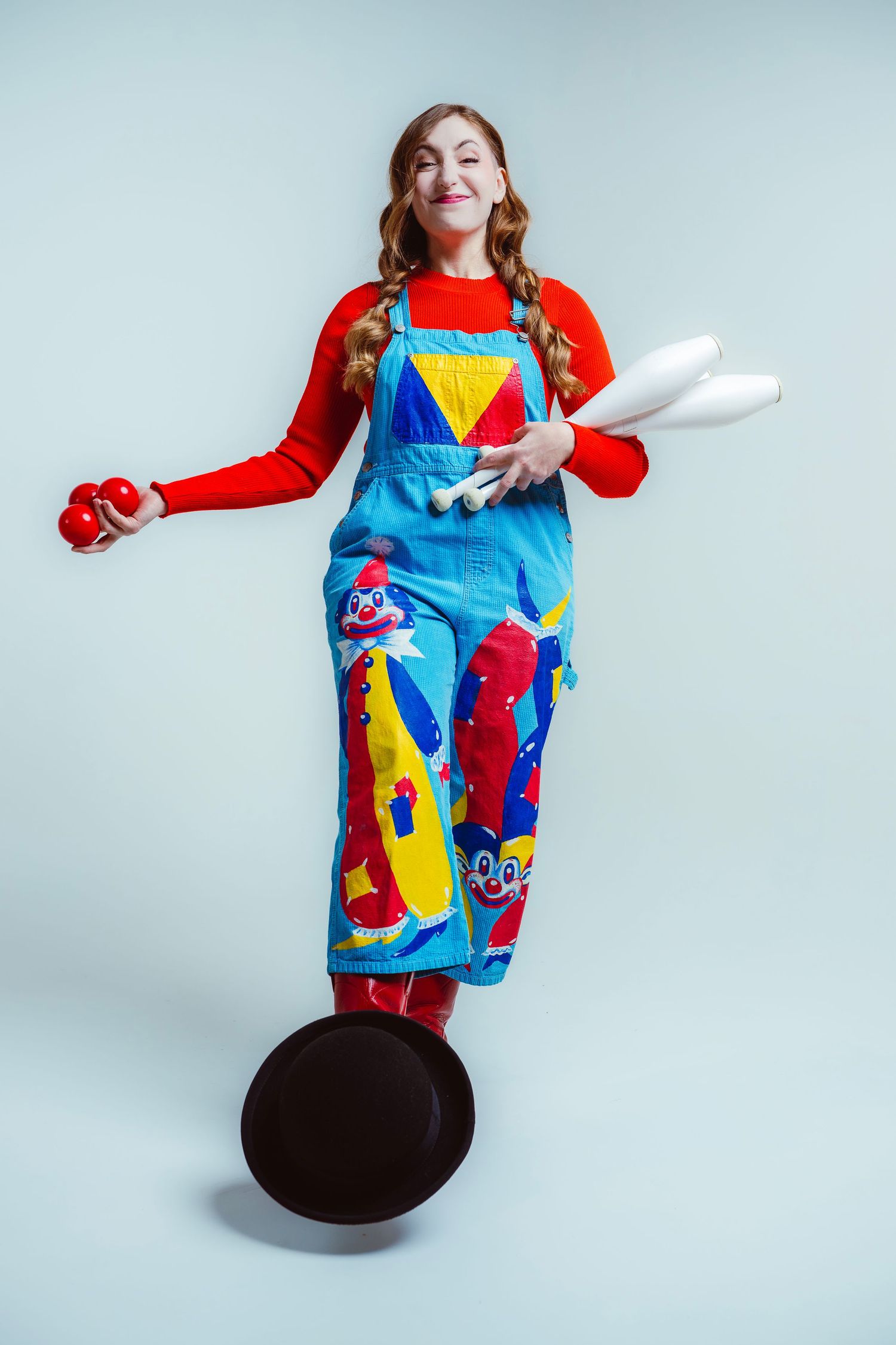 Colorful apron with vibrant geometric pattern and cartoon designs shown in multiple poses against light blue background.