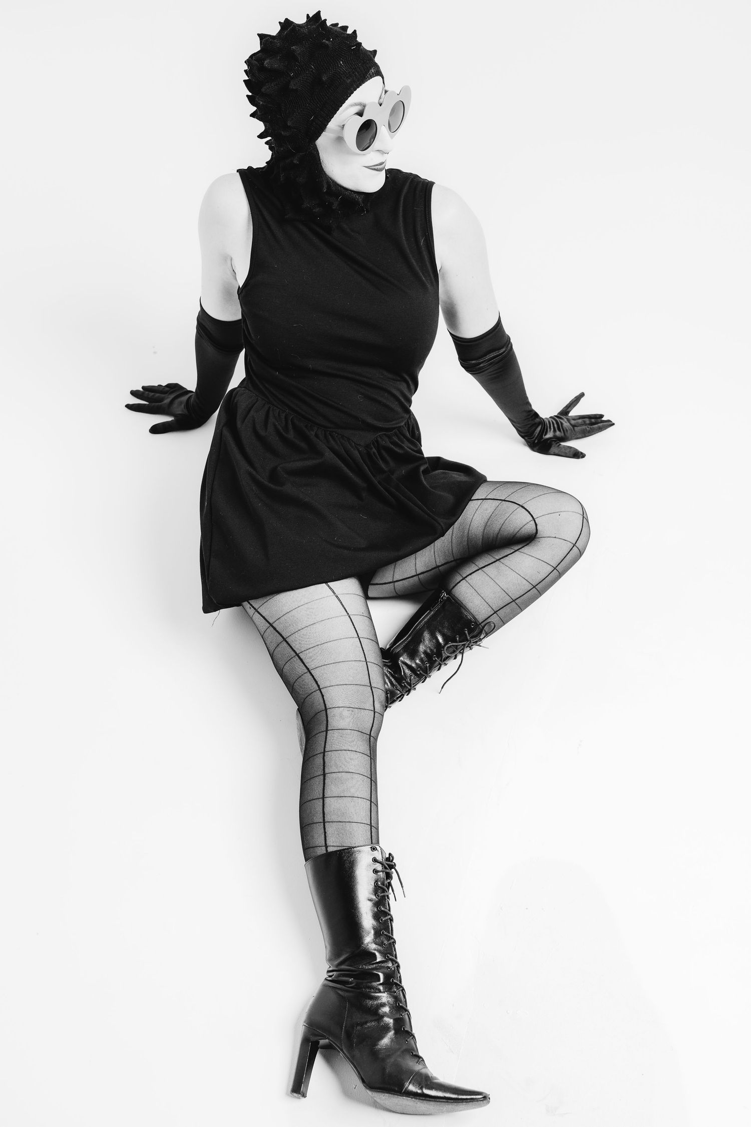 Black and white fashion photo series showing legs in plaid tights and boots against white background.
