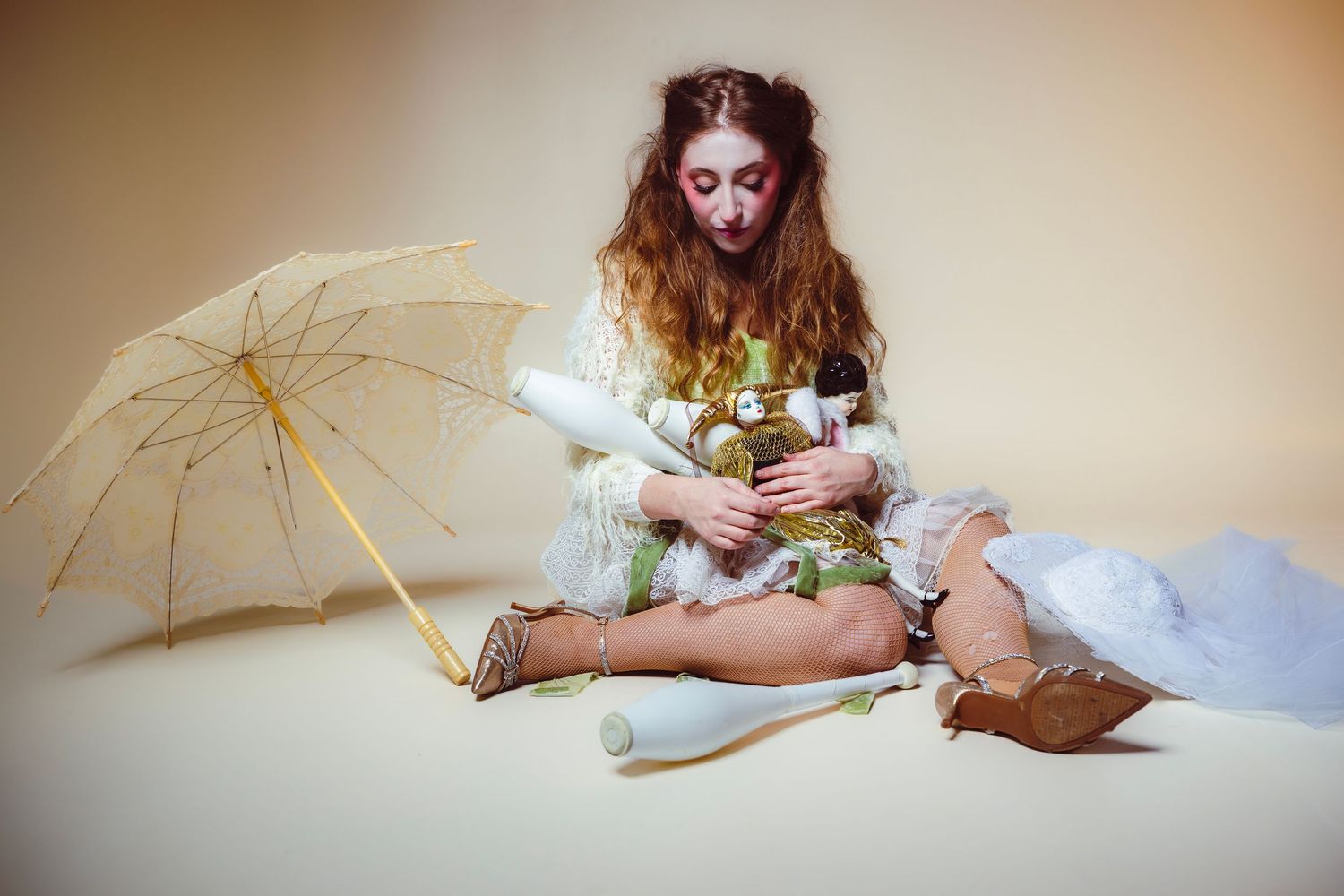 A white lace parasol sits elegantly against a soft beige background in a vintage-style composition.