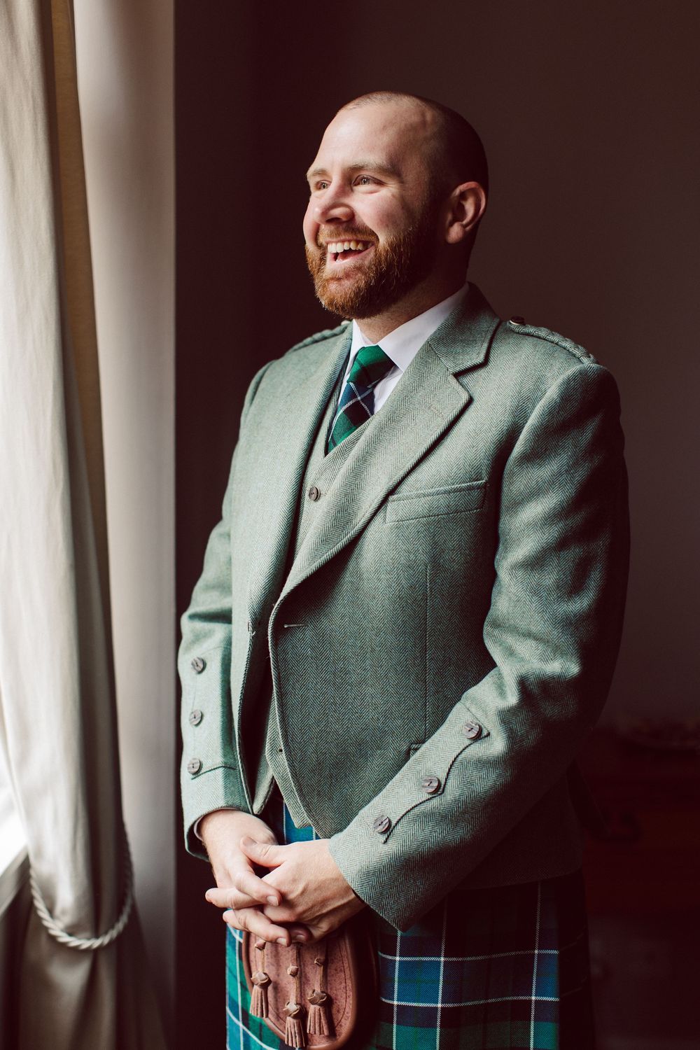 A series of portraits showing a person in a green suit jacket and tartan kilt posing near a window.