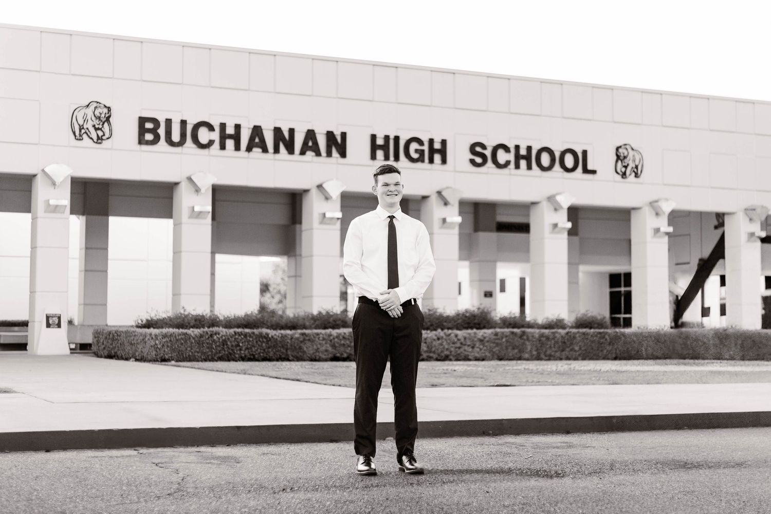 Exterior view of Buchanan High School building entrance with white columns and signage.