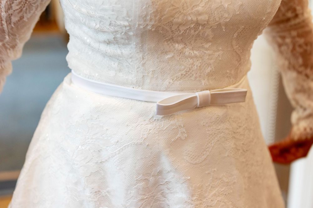 A detailed photo of a white wedding dress bow.