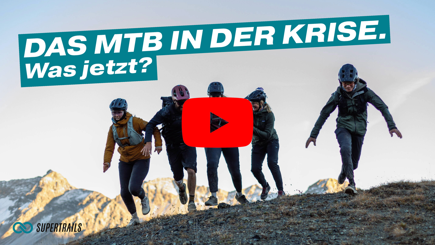 Silhouettes of mountain bikers standing on a ridge against a mountain backdrop with a video play button overlay.