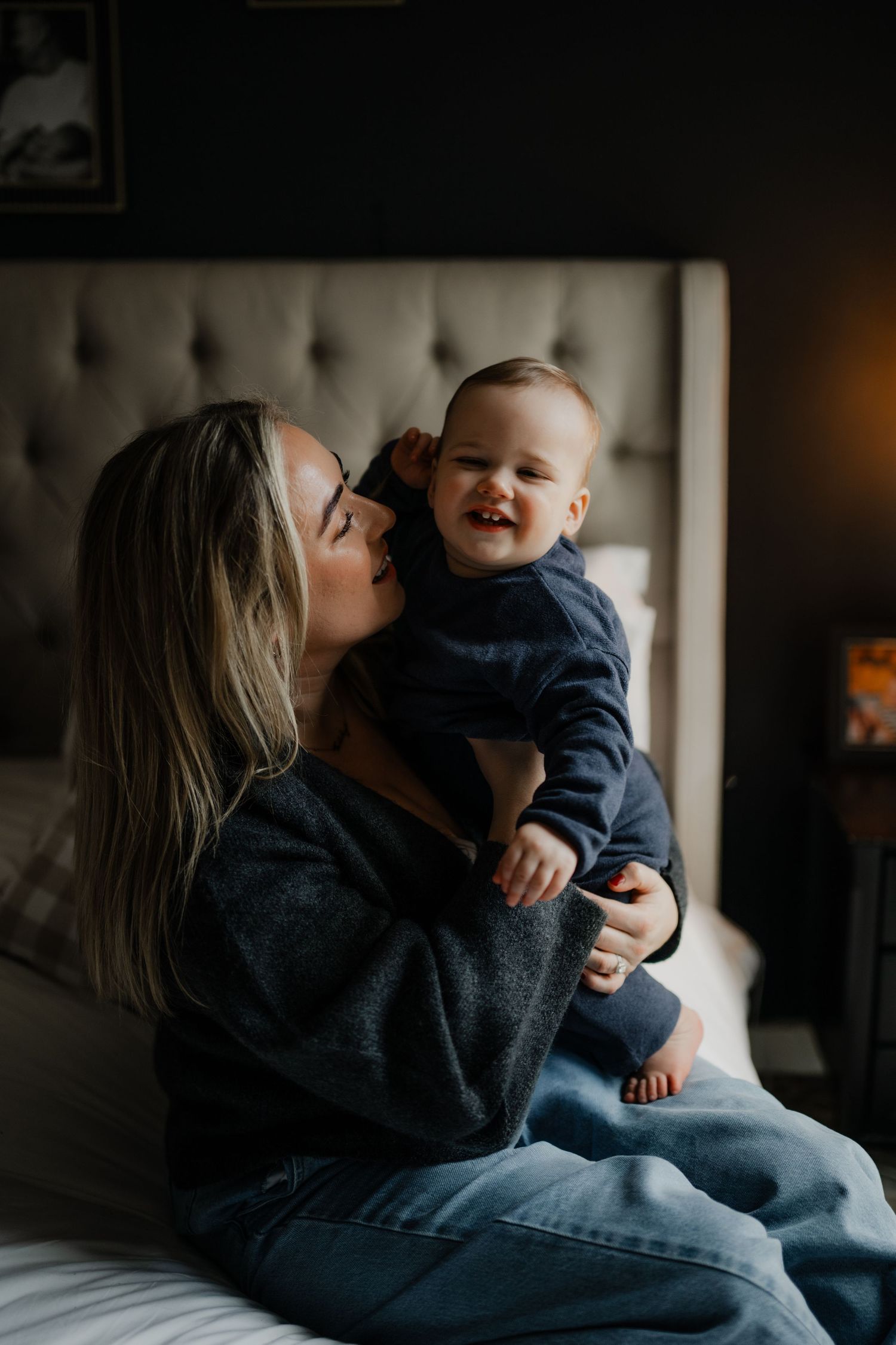 a mother looking lovingly at her son while the boy is laughing looking into the camera