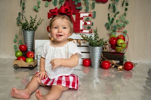 White and red themed holiday scene with fresh eucalyptus sprigs and fruit decorations.