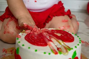 Red and white frosted dessert with green sprinkles and decorative details.