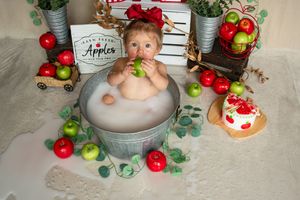 Festive Christmas scene with silver buckets, red and white gingham letters, apples and eucalyptus garland decorations.