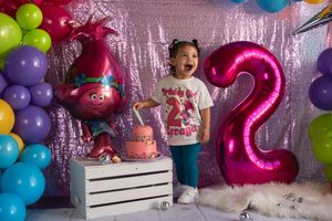 Colorful balloon decorations with pink, blue, and green balloons against a sparkly backdrop for a festive celebration.