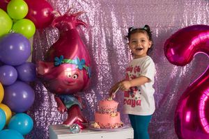 Pink and purple balloons create a festive backdrop for a birthday celebration with party decorations.
