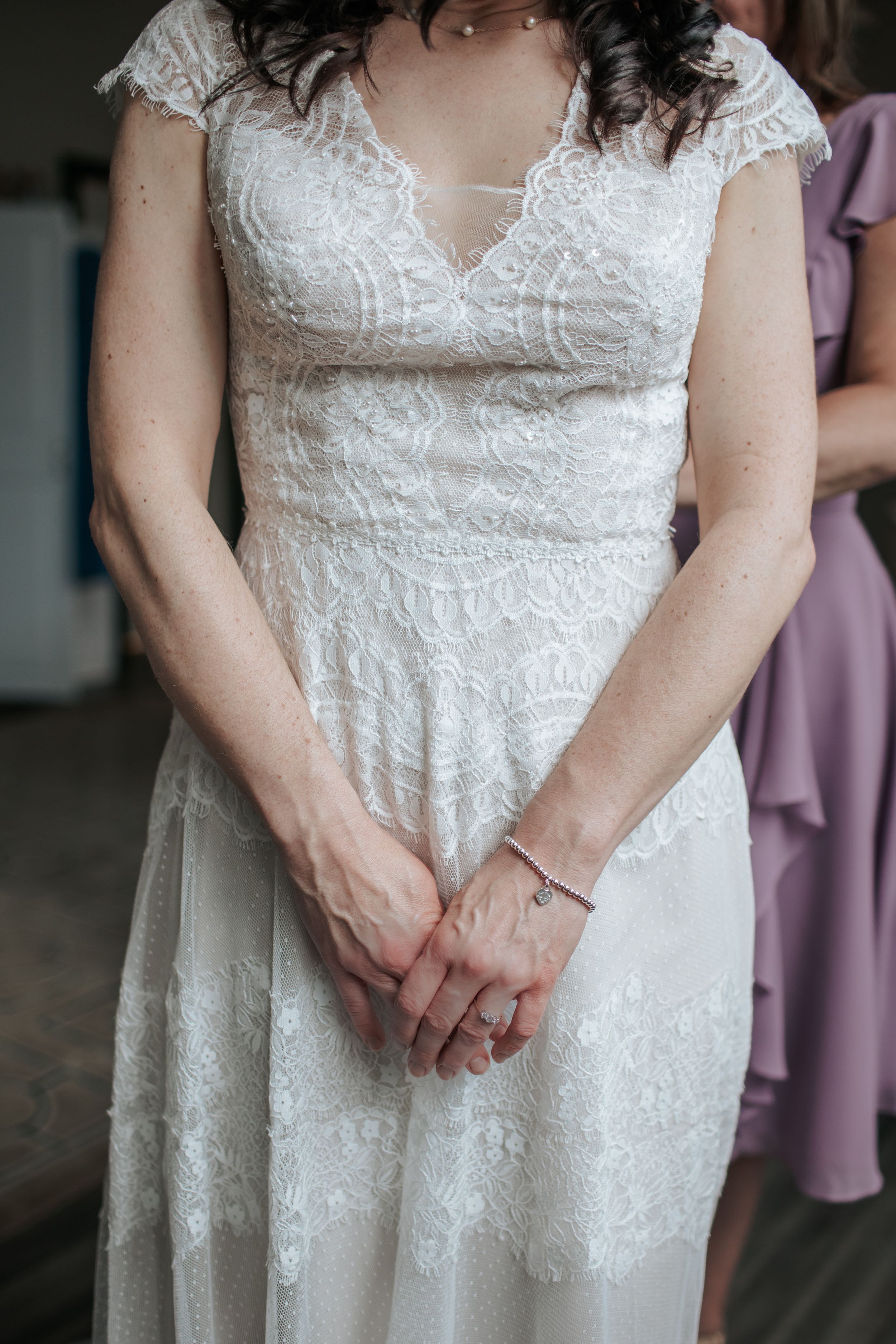 Close-up detail shots of a white lace wedding dress bodice with delicate embroidery and cap sleeves.