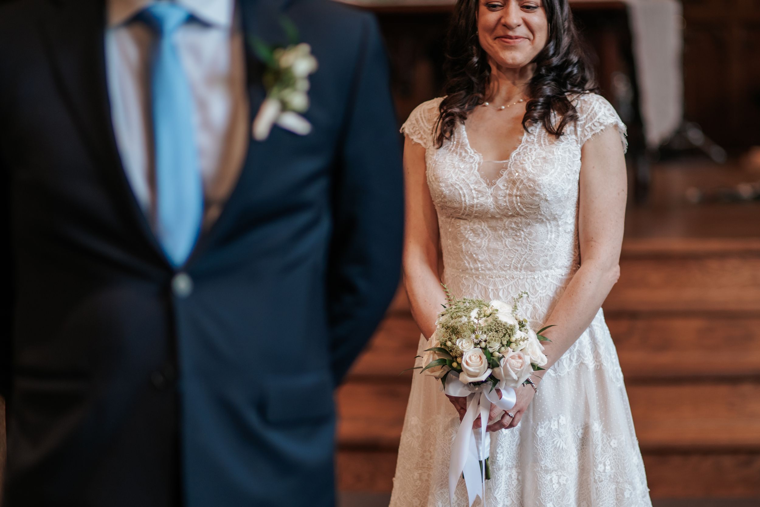 A couple stands together during their wedding ceremony while holding hands and exchanging vows.