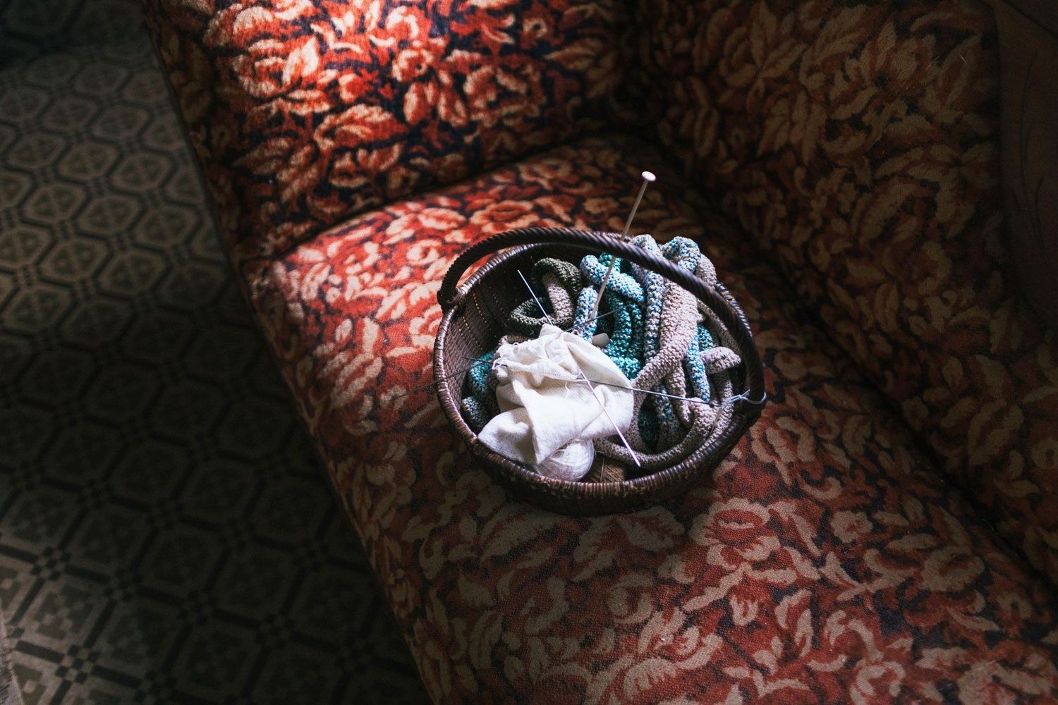 Knitting needles in basket with crochet on a red cream damask antique couch at Canterbury Shaker Village. New England photographer.