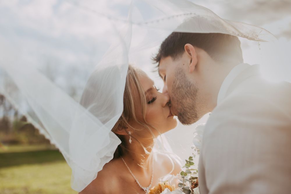 Bride and Graham kissing under a veil at Sunset in Zionsville, Indiana